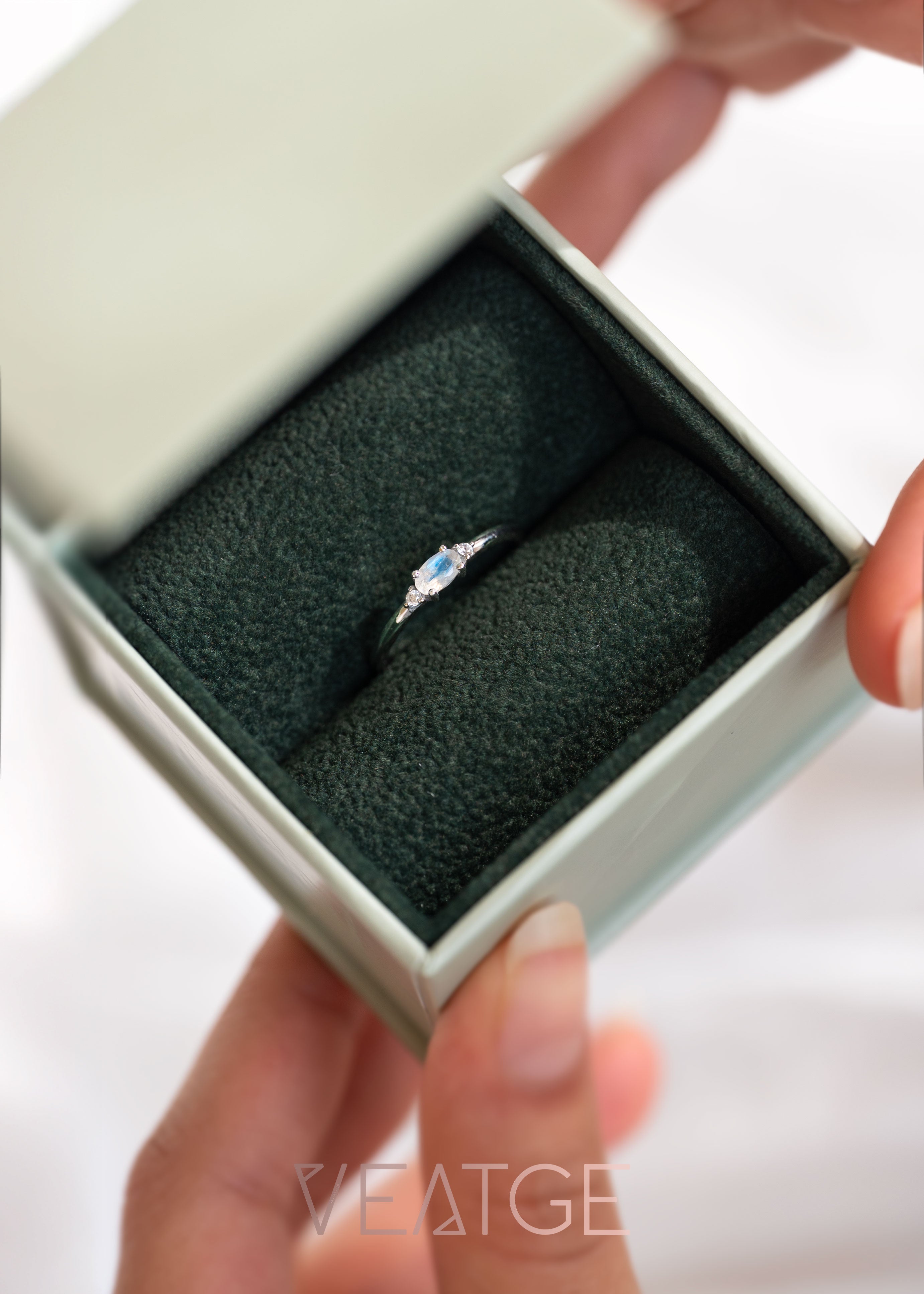 Silver dainty stacking ring with a real moonstone, branded "VEATGE".