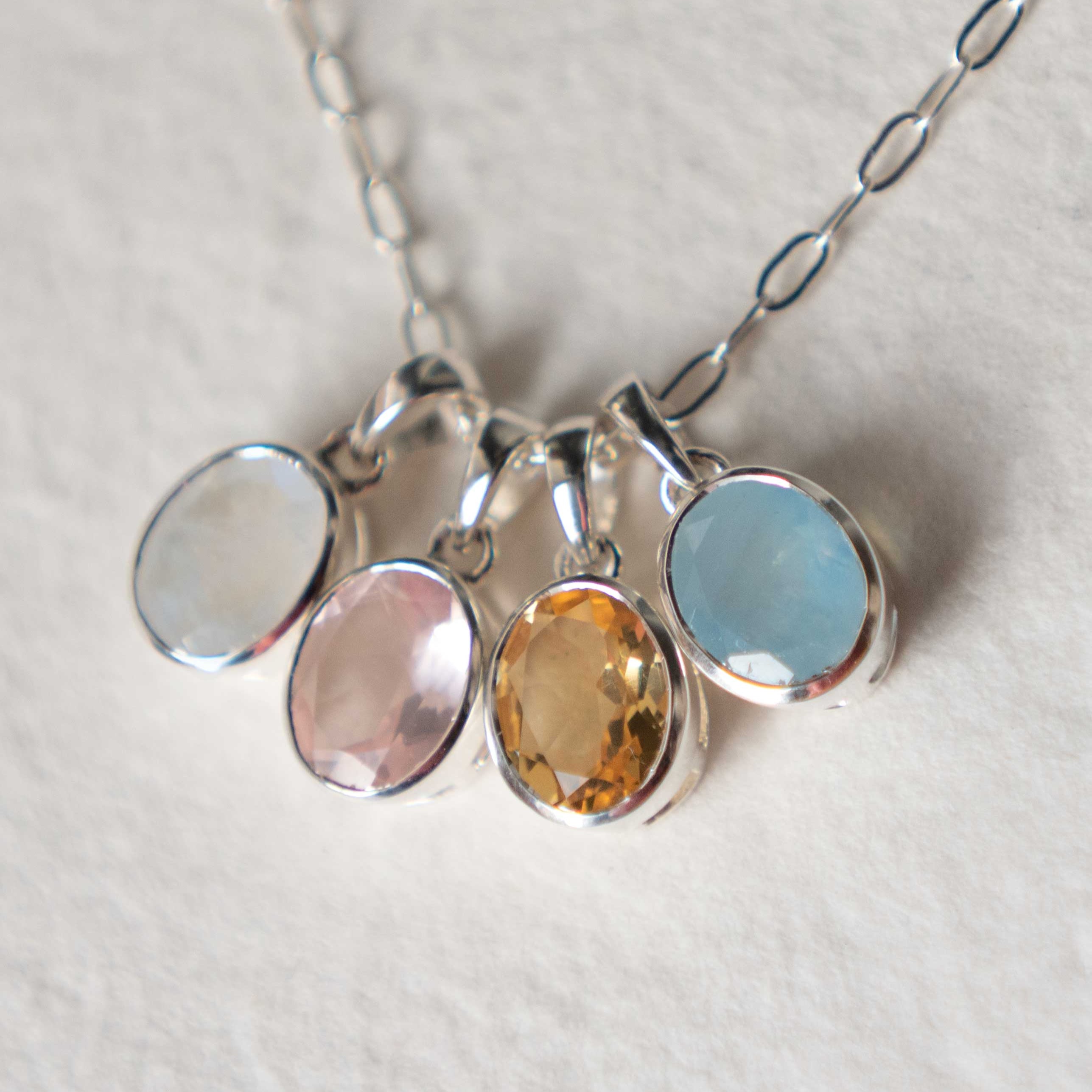 Necklace with four round gemstones on a light background