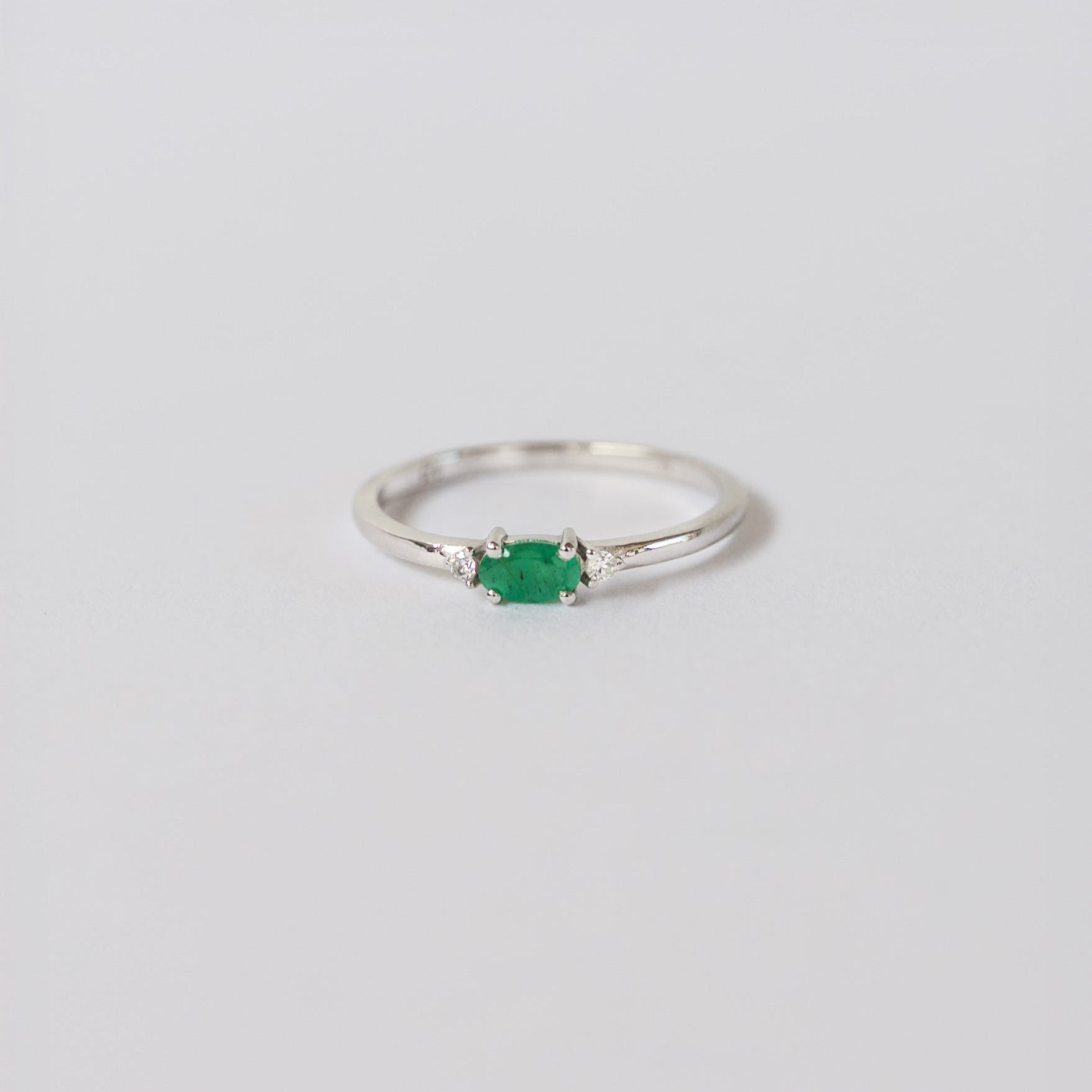 Silver dainty stacking ring with a real emerald gemstone, branded "VEATGE"