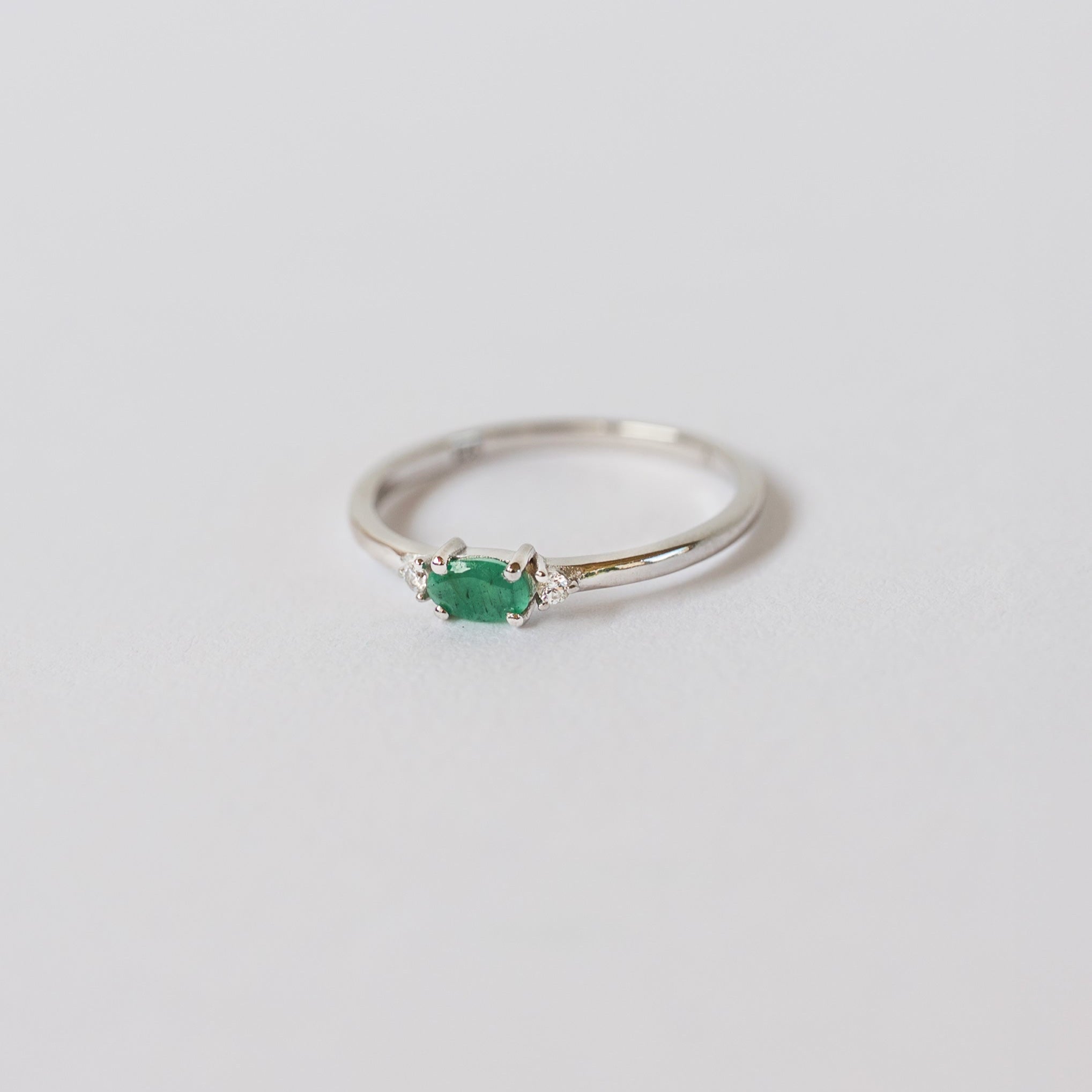 Silver dainty stacking ring with a real emerald gemstone, branded "VEATGE"