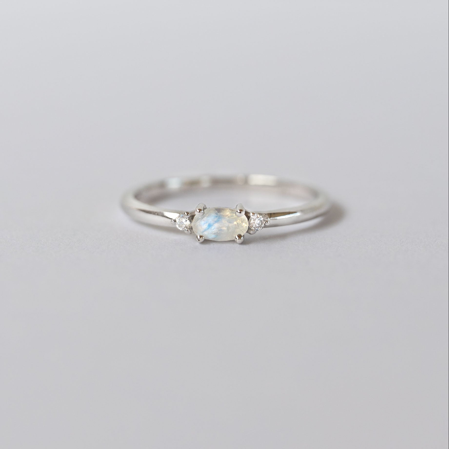 Silver dainty stacking ring with a real moonstone, branded "VEATGE".
