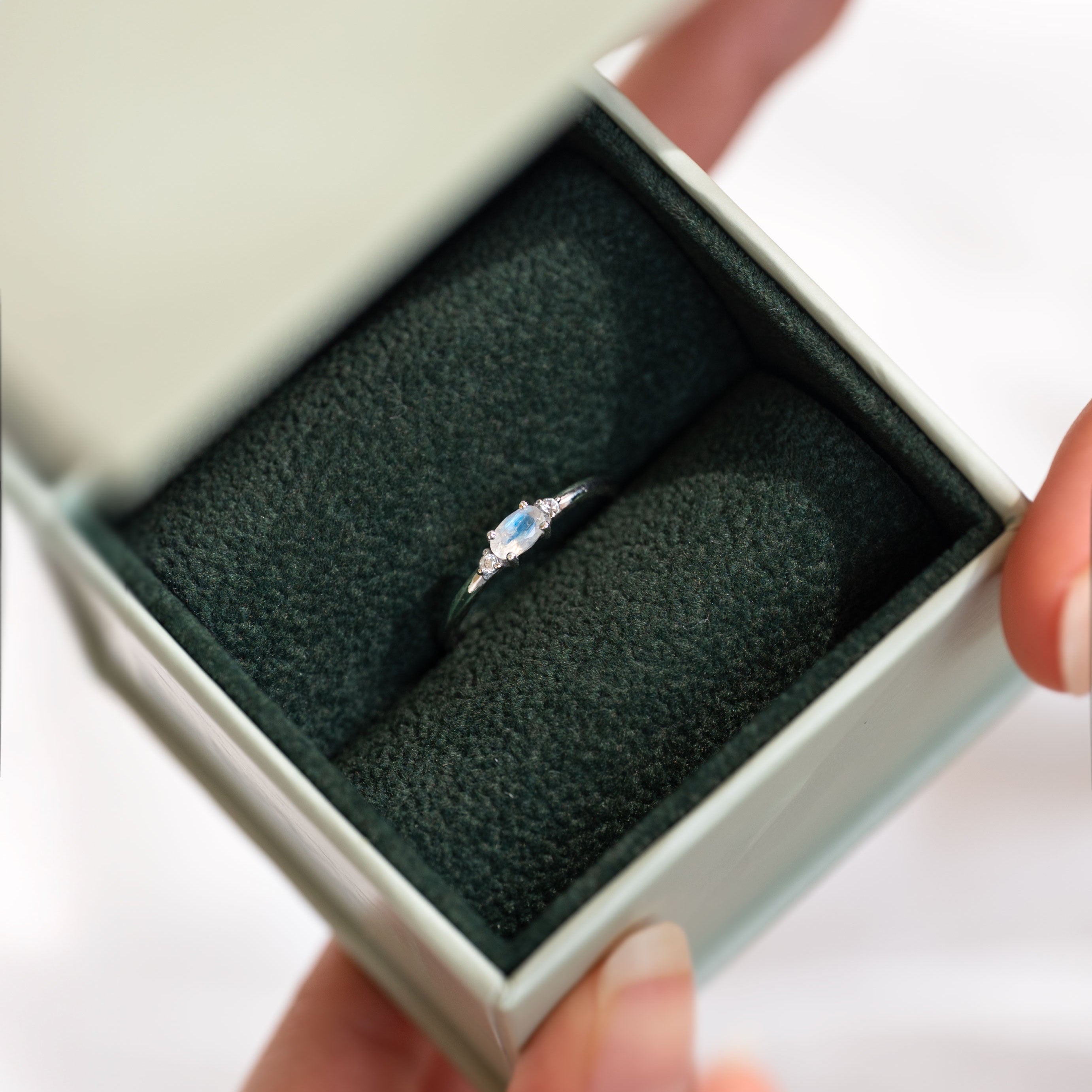 Silver dainty stacking ring with a real moonstone, branded "VEATGE".