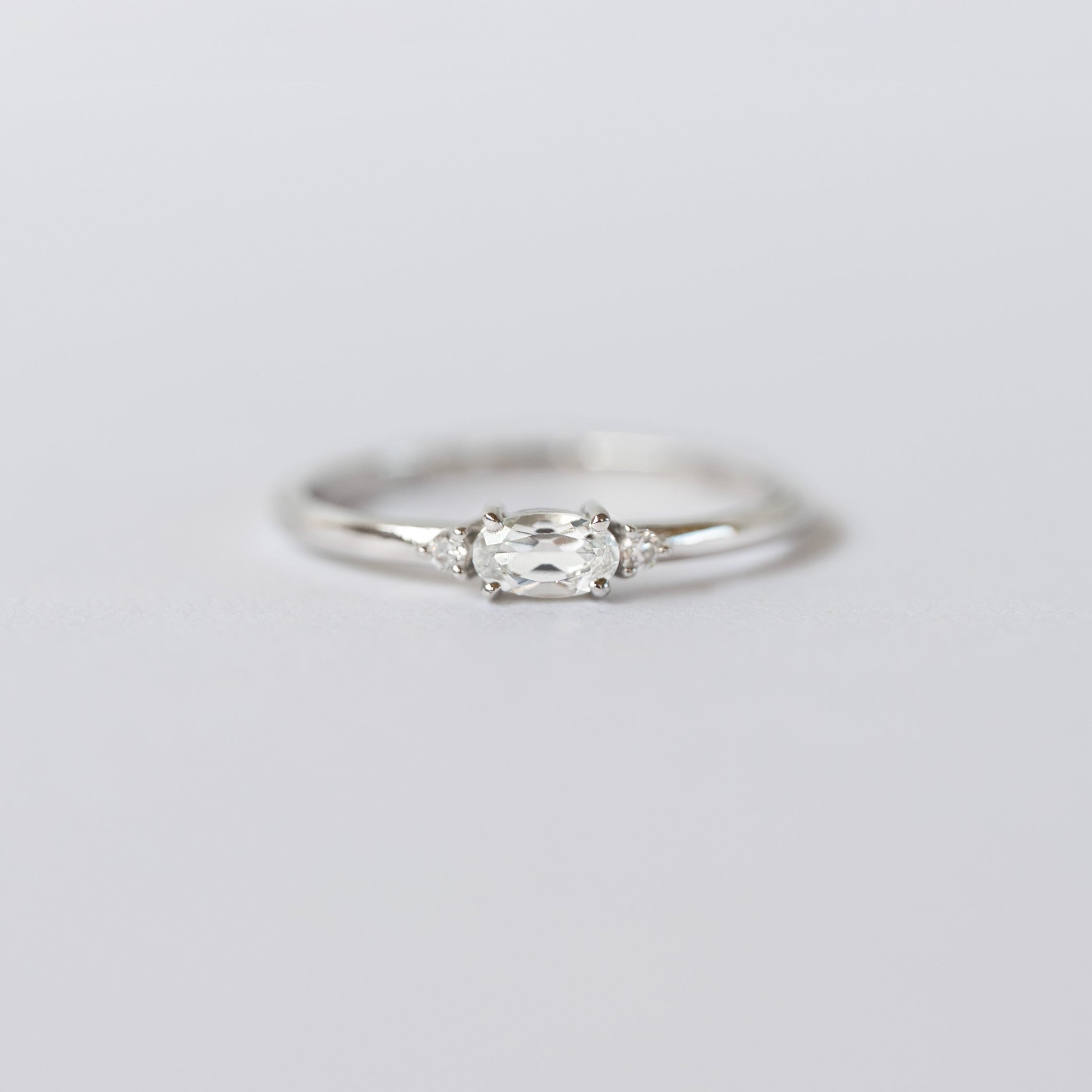 Silver ring with a diamond on a light gray background, branded 'VEATGE'.