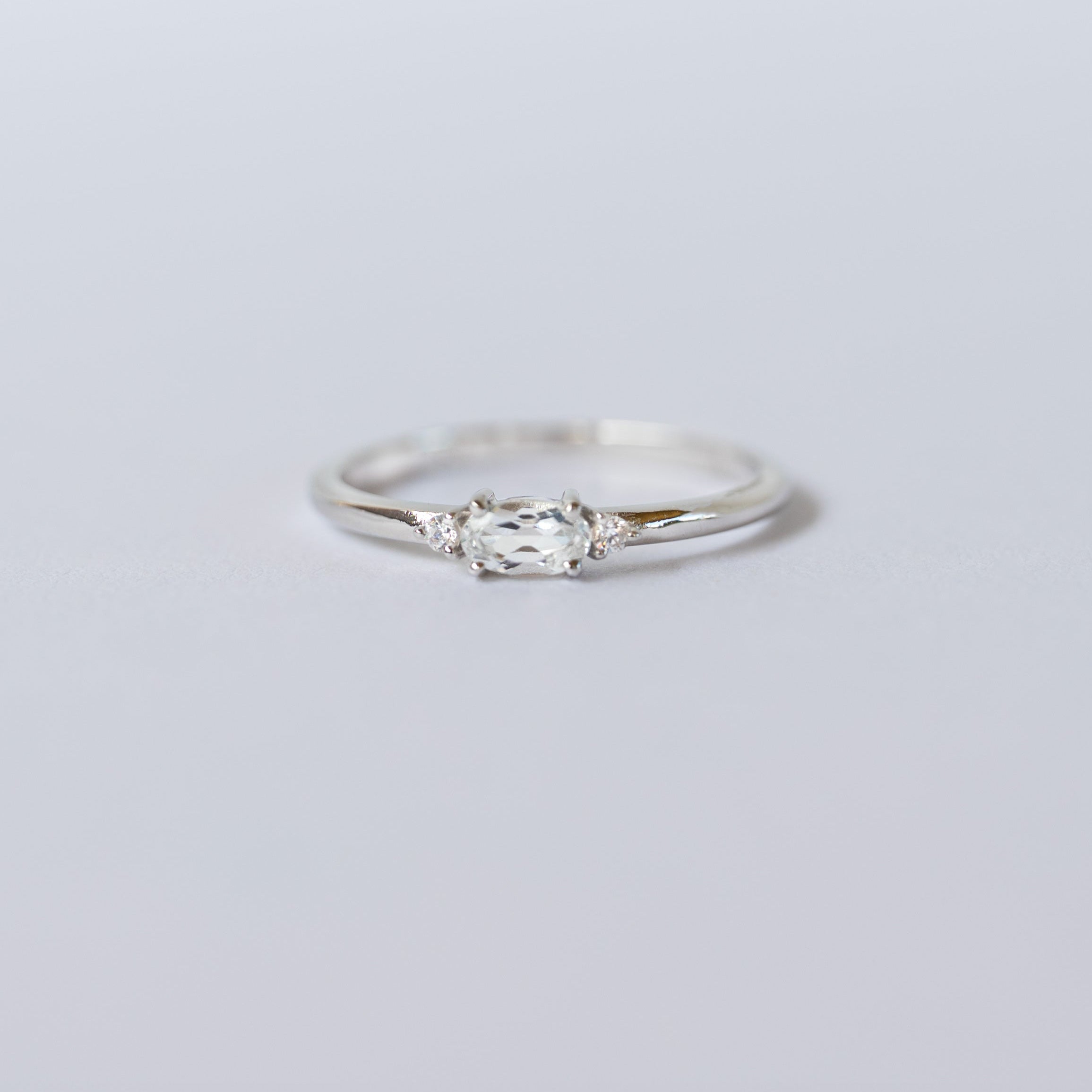 Silver ring with a diamond on a light gray background, branded 'VEATGE'.