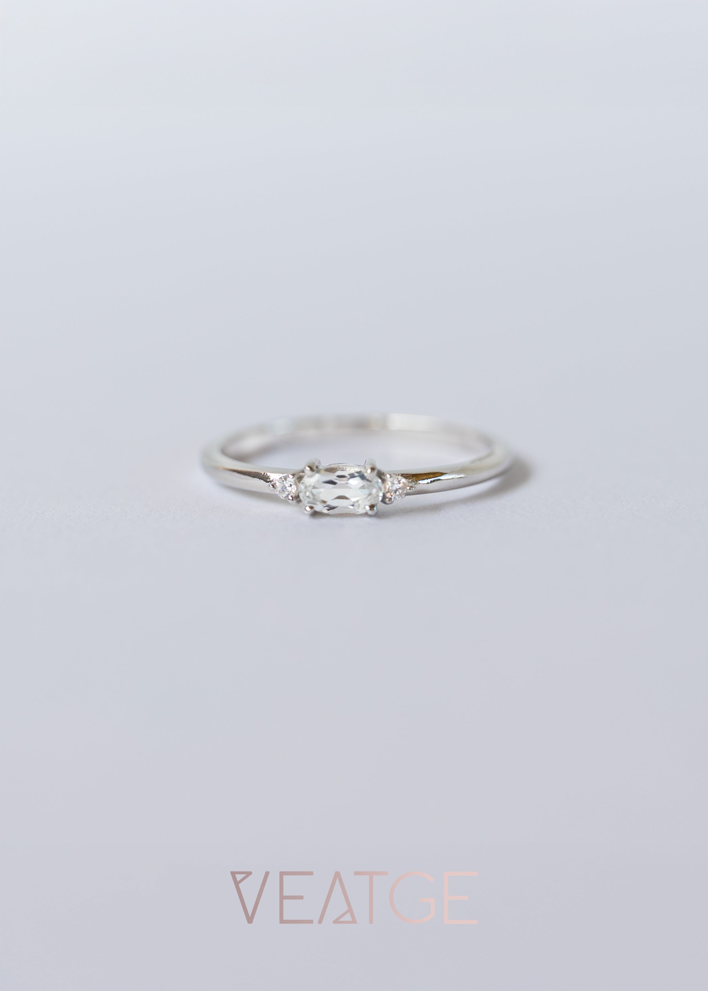 Silver ring with a diamond on a light gray background, branded 'VEATGE'.