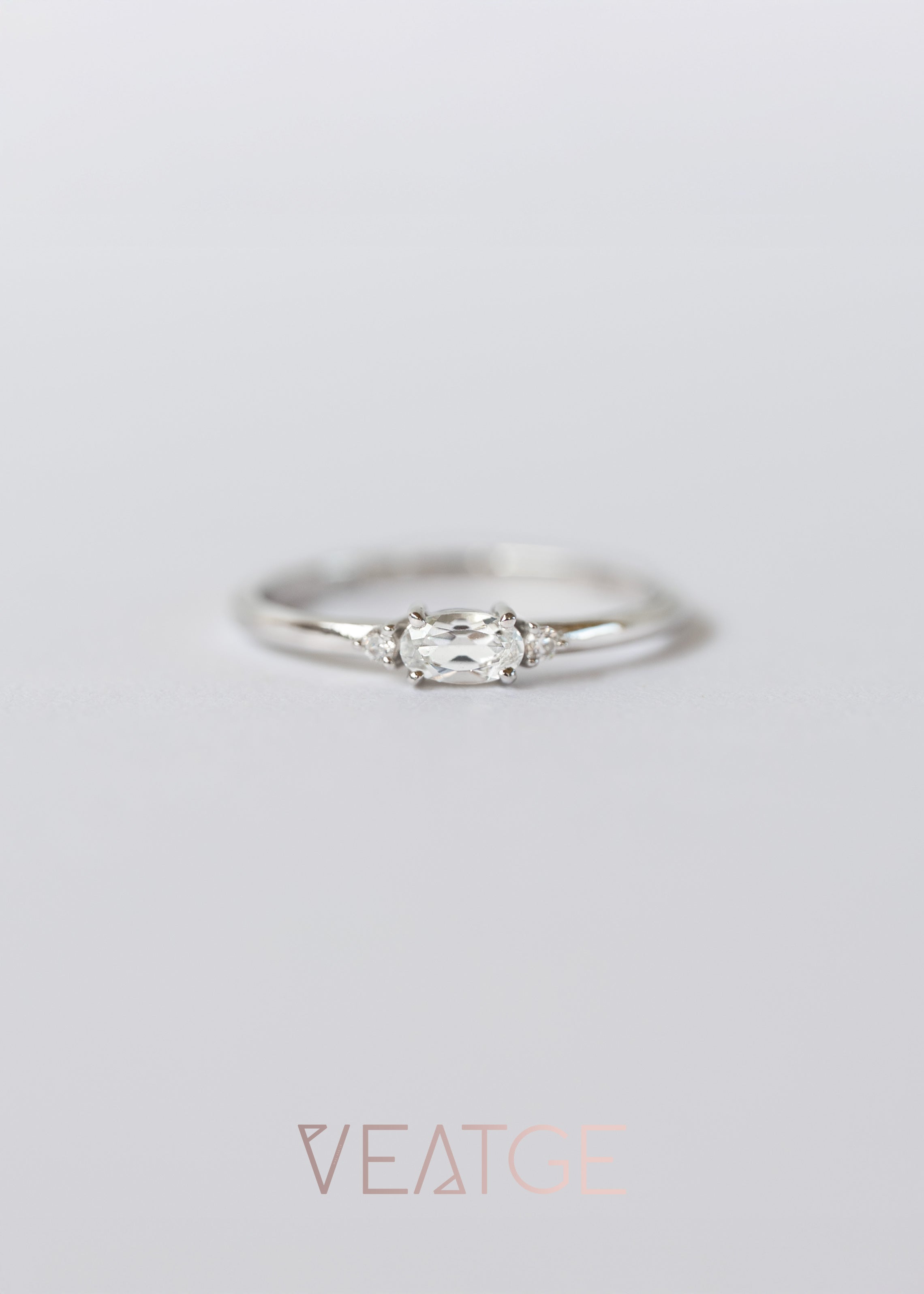 Silver ring with a diamond on a light gray background, branded 'VEATGE'.