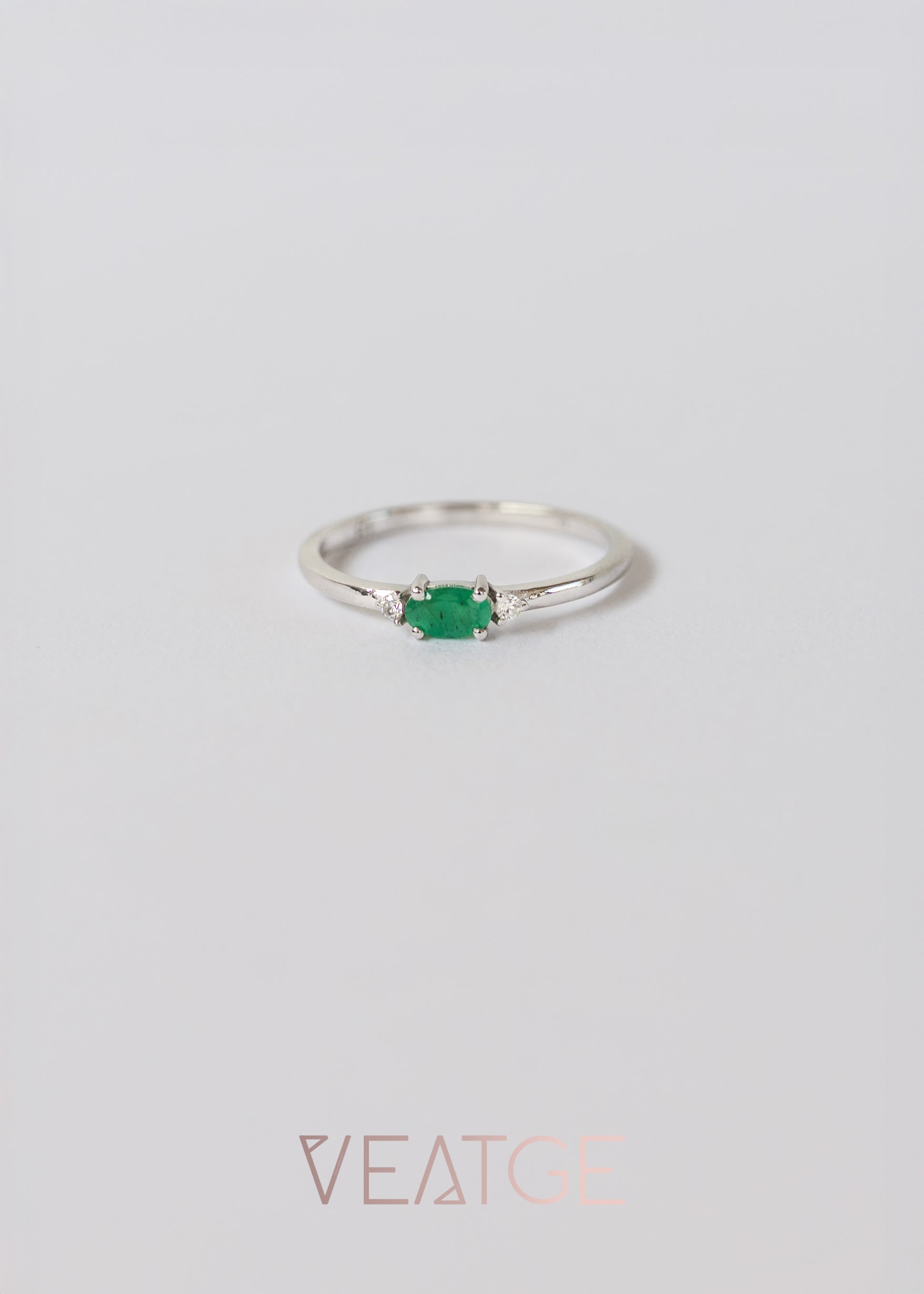 Silver dainty stacking ring with a real emerald gemstone, branded "VEATGE"