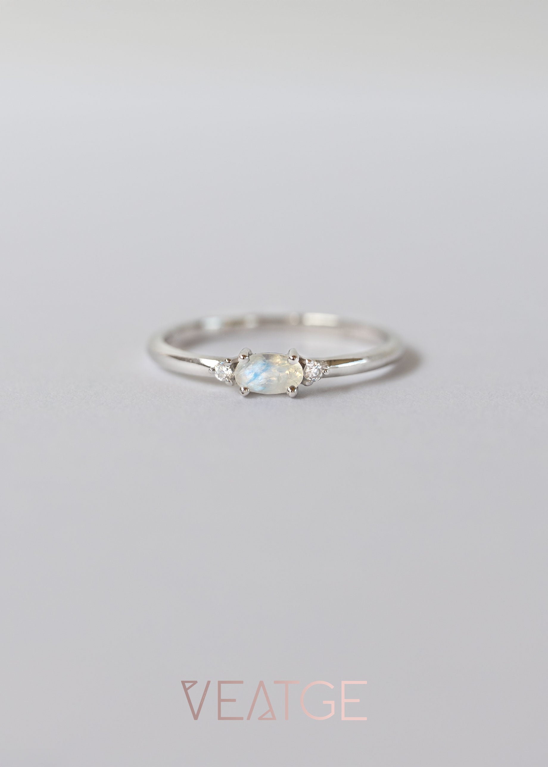 Silver dainty stacking ring with a real moonstone, branded "VEATGE".